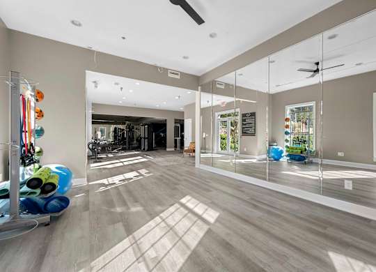 a gym with mirrors in a large room with hardwood floors