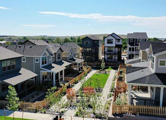 an aerial view of a row of houses and a green yard