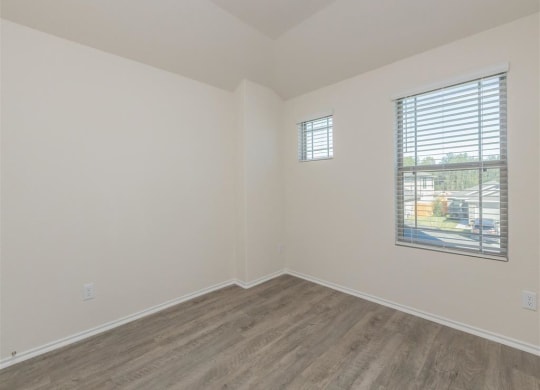 a bedroom with white walls and a window at The Village at Granger Pines, Texas
