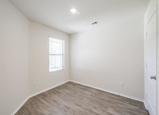 an empty room with a window and a door at The Village at Granger Pines, Conroe Texas