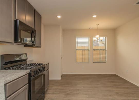 a kitchen with a stove top oven next to a window at The Village at Granger Pines, Conroe