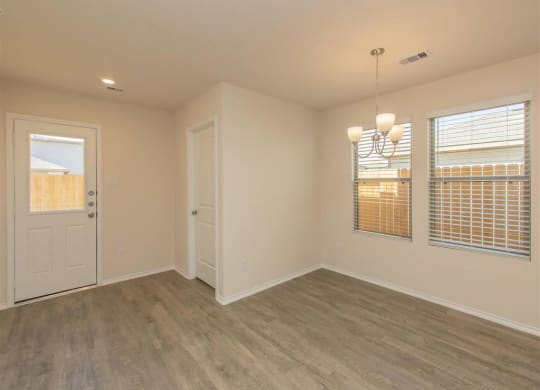 a bedroom with a door and two windows at The Village at Granger Pines, Texas, 77302