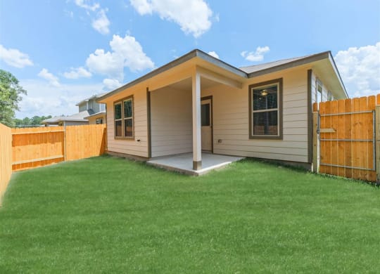 a house with a yard and a fence at The Village at Granger Pines, Conroe, TX