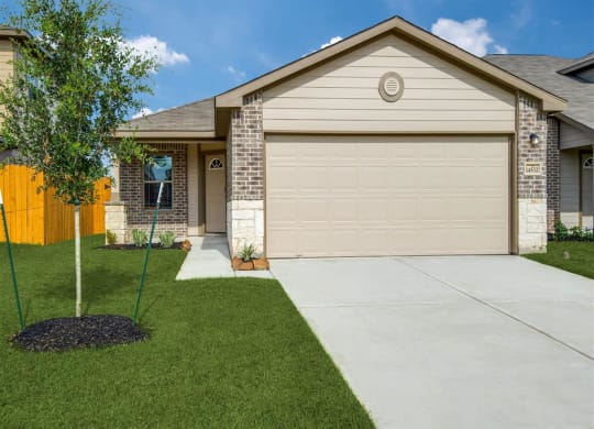a house with a garage and a tree in the front yard   at The Village at Granger Pines, Conroe, TX 77302