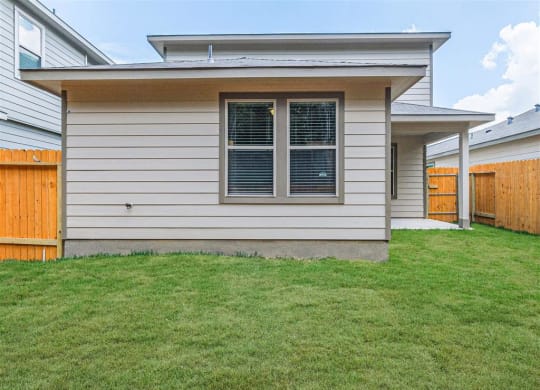 a house with a wooden fence and a green lawn at The Village at Granger Pines, Conroe Texas