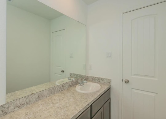 a bathroom with a sink and a mirror at The Village at Granger Pines, Conroe