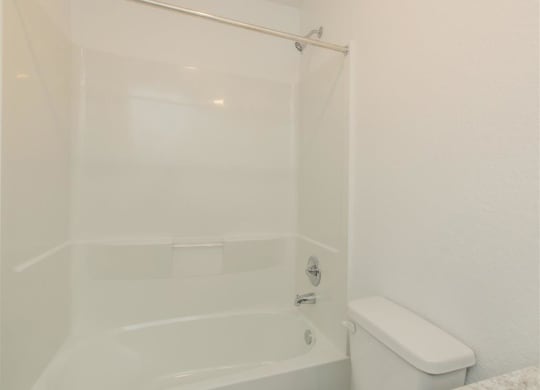 a white bath tub sitting next to a white toilet at The Village at Granger Pines, Conroe Texas