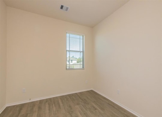 an empty room with white walls and a window at The Village at Granger Pines, Conroe, TX