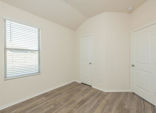 a bedroom with two doors and a window at The Village at Granger Pines, Conroe, TX