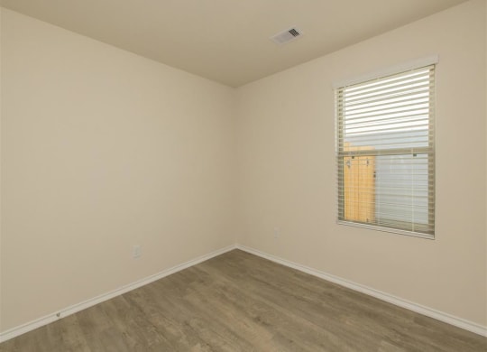 a bedroom with a window and a wooden floor at The Village at Granger Pines, Conroe, TX