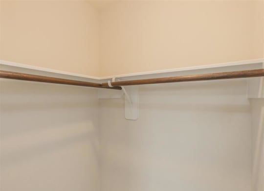 a walk in closet with a white shower curtain and a wooden rail at The Village at Granger Pines, Texas, 77302