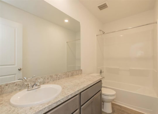 a bathroom with a sink toilet and shower at The Village at Granger Pines, Texas