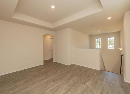 a large empty room with white walls and a wooden floor at The Village at Granger Pines, Conroe Texas
