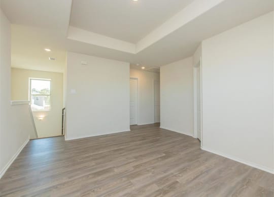 a bedroom with hardwood floors and white walls at The Village at Granger Pines, Texas
