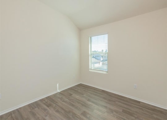 a bedroom with white walls and a window at The Village at Granger Pines, Conroe, TX