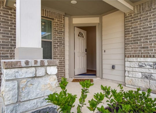 a home entryway with a white door and brick walls at The Village at Granger Pines, Texas
