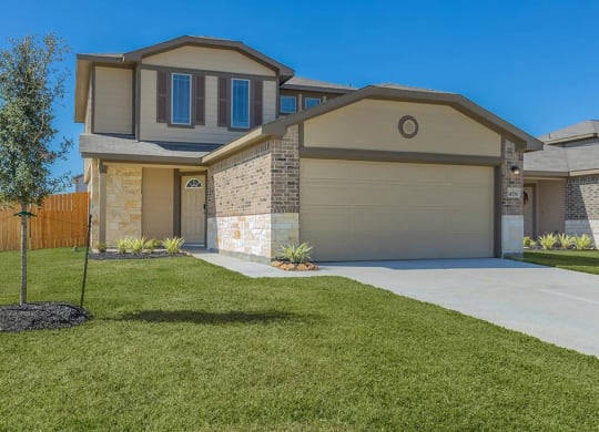 a house with a lawn and a tree in front of it at The Village at Granger Pines, Conroe