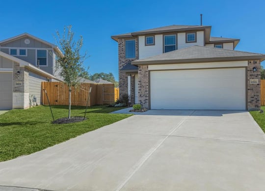 a house with a white garage door at The Village at Granger Pines, Conroe Texas