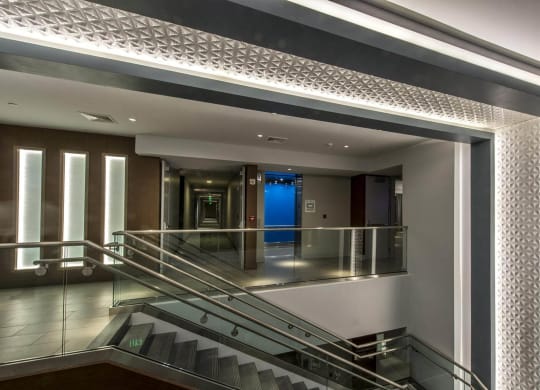 the lobby of a building with stairs and a blue door
