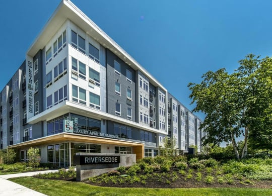 The exterior of RE150 Apartments in Medford, MA, featuring a modern facade and a sign reading "Riversedge".