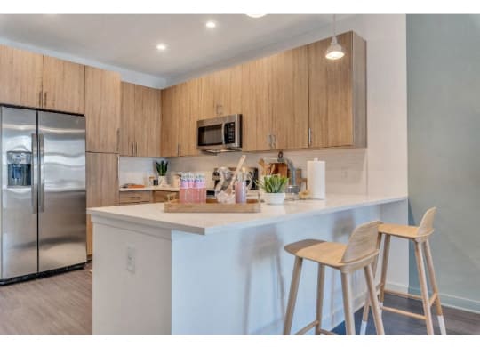 a kitchen with two bar stools and a refrigerator
