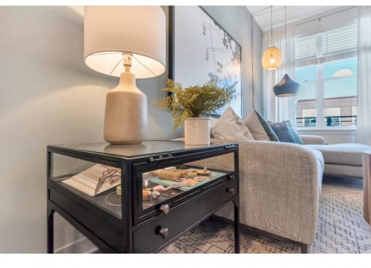 a living room with a couch and a table with a lamp