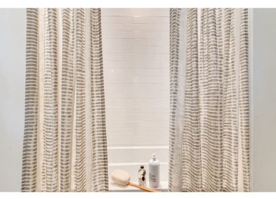 a bathroom with a shower curtain and a white tub