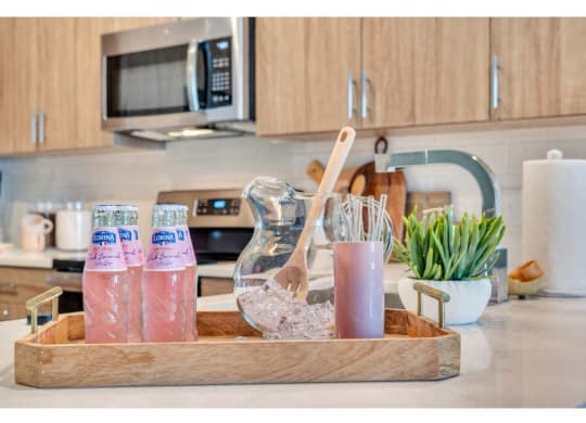 a tray with drinks and utensils on a kitchen counter