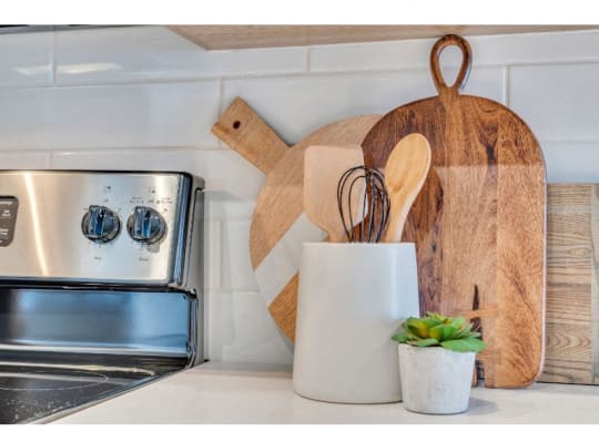 a kitchen with a stove and some wooden utensils on the counter