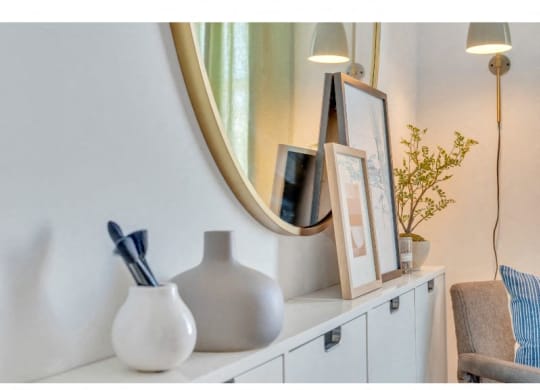 a white shelf with a mirror and a vase on it