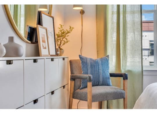 a chair with a blue pillow sitting next to a window