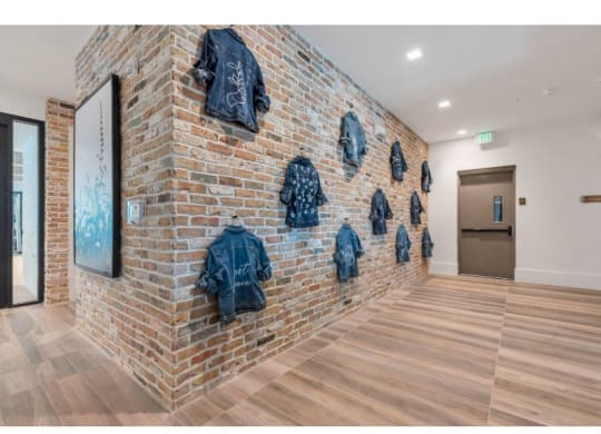 the room has a brick wall with jackets on it