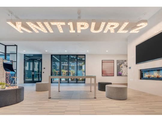 a large lobby with a table and a fireplace