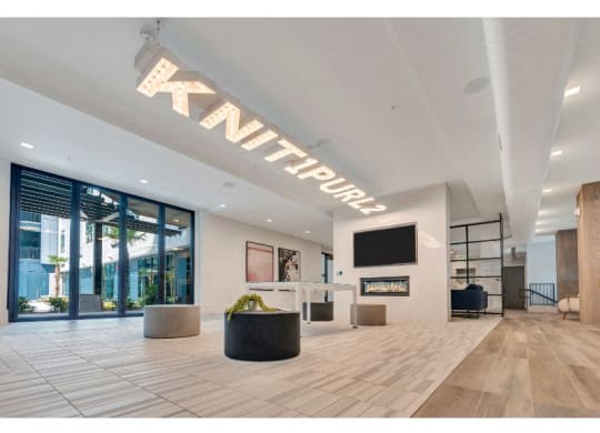 a large lobby with a tv and a glass door