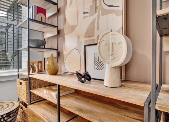 a living room with a wooden shelf and a table with a sculpture
