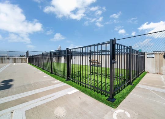 a fence with a field behind it in a parking lot