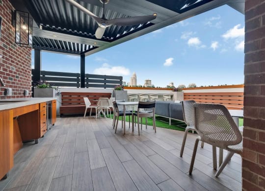 a roof deck with tables and chairs and a view of the city