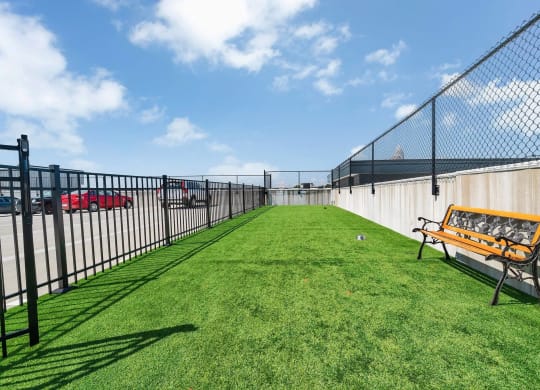 a fenced in yard with a bench and a chain link fence