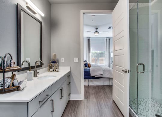a bathroom with a shower and a sink and a mirror