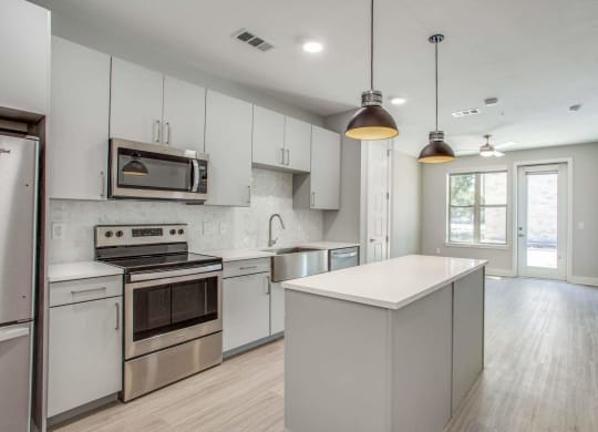 a kitchen with white cabinets and stainless steel appliances