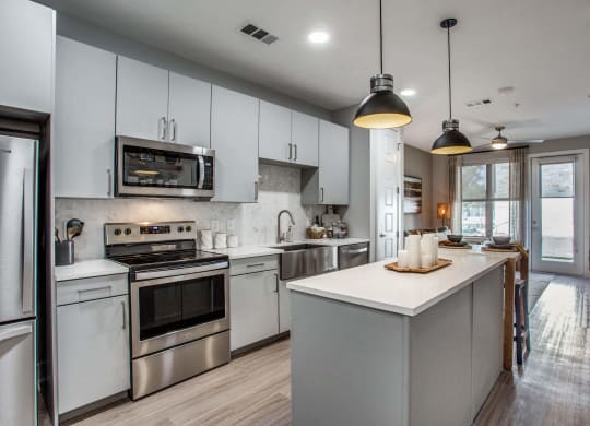 a kitchen with white cabinets and stainless steel appliances
