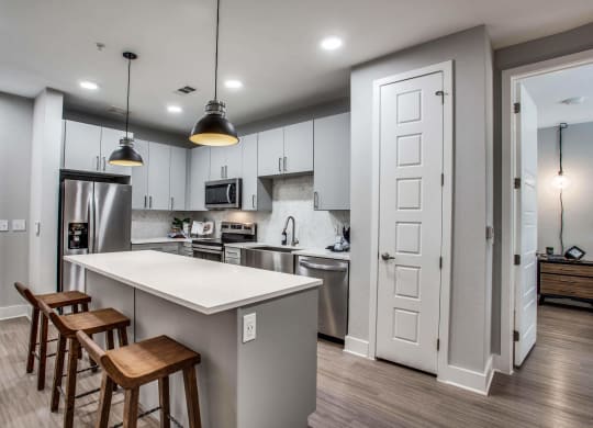 a kitchen with a large island with three stools