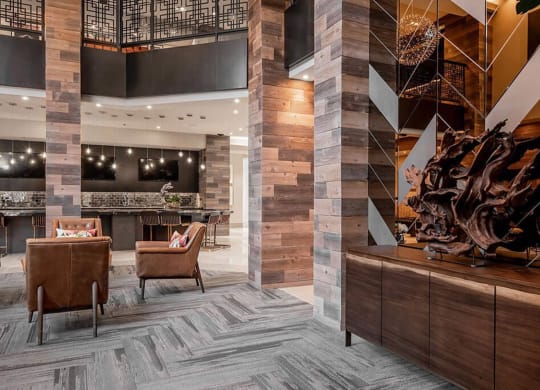 a lobby of a hotel with chairs and a bar