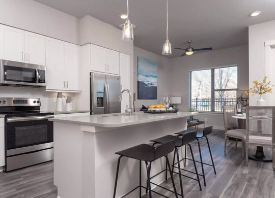 a kitchen with a large island with three bar stools