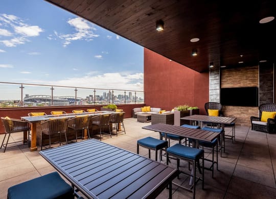a rooftop patio with tables and chairs and a view of the city