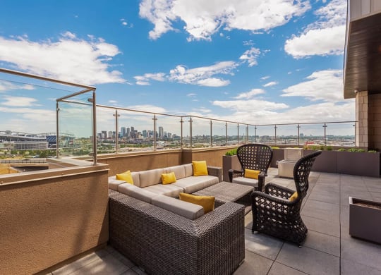 a balcony with a view of a city and a patio with furniture