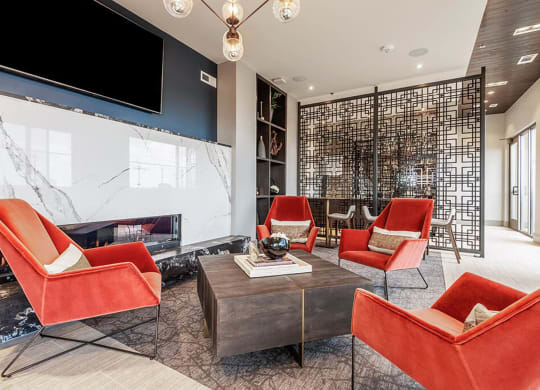 a living room with red chairs and a fireplace