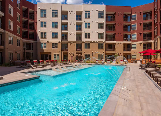 a swimming pool in front of an apartment building