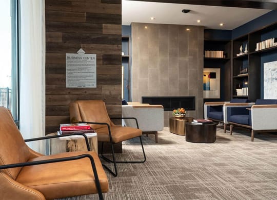 a lobby of a hotel with chairs and a fireplace
