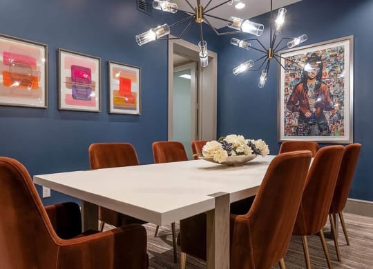 a dining room with blue walls and a white table and chairs